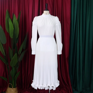 Detailed view of white pleated chiffon dress with puff sleeves and stand collar details