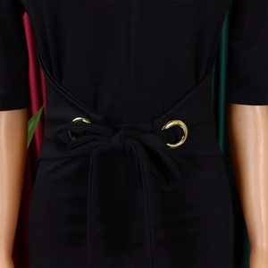 Detail of waist design on black pencil dress with golden eyelets and elegant ribbon bow