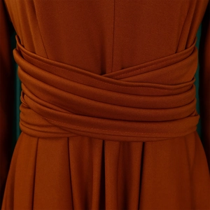 Close-up of caramel knit dress waist with layered cross-wrap pleated design