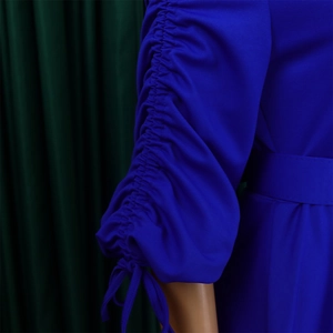 Détail de manches bouffantes plissées bleu roi avec cordon et ceinture assortie