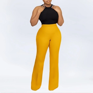 Detail view of high-waist wide-leg yellow trousers paired with a black ribbed knit top
