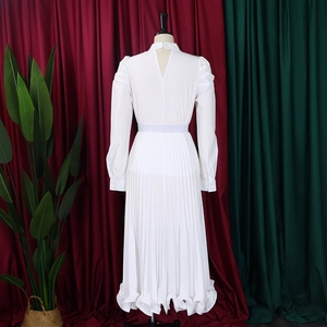Detail of white puff sleeve top and pleated skirt set back with keyhole button
