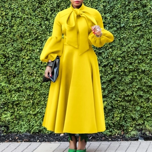 Elegant yellow maxi dress featuring lantern sleeves and a large bow tie at the neckline