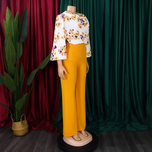 Détail d'un chemisier à fleurs à manches évasées et d'un pantalon large jaune ensemble