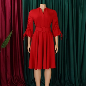 Détail d'une robe midi rouge à col en V avec poignets plissés et ceinture à boucle assortie