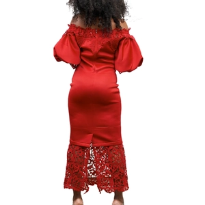 Detail of red off-shoulder evening dress with lantern sleeves and floral lace hemline