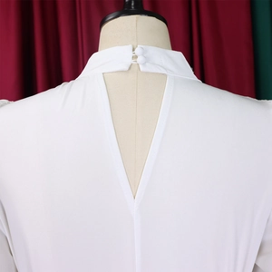 Detail of white puff sleeve top featuring a high neck with back keyhole and button closure