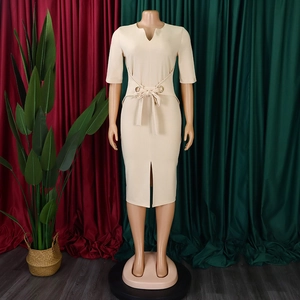 Detail of beige pencil dress featuring V-neckline and waist tie with golden metal eyelets