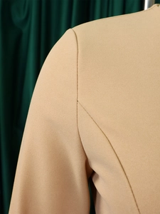 Detail view showing refined shoulder stitching on a beige V-neck pencil dress for women