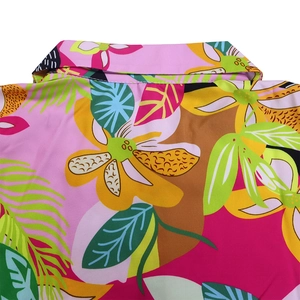 Close-up of tropical floral print on a long sleeve shirt collar with vibrant leaf patterns