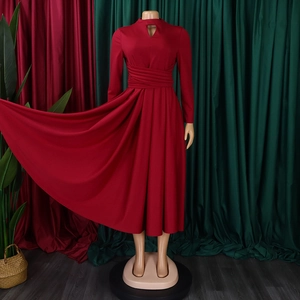 Detail of deep red pleated dress featuring a teardrop cutout neckline and waist drapes
