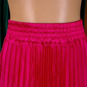 Détail macro d'une jupe plissée à taille haute avec ceinture élastique et satin de soie magenta