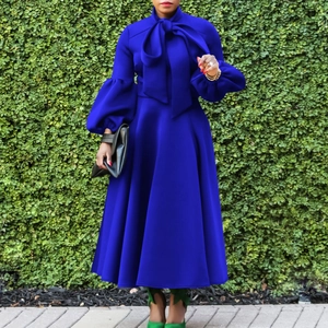 Detail of royal blue lantern sleeve dress featuring high waist and large neck bow