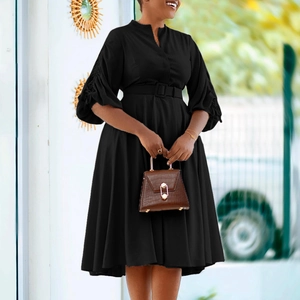 Détail d'une robe noire évasée avec manches lanternes et ceinture pour une silhouette