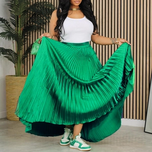 Détail de la jupe longue plissée vert vif avec taille haute élastique et tissu satiné