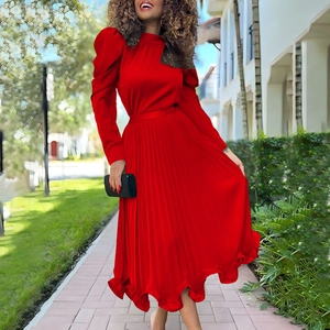 Detail view of red pleated dress with puff sleeves and ruffled hem in elegant style