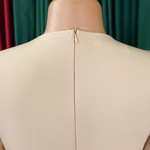 Detail shot of a beige pencil dress featuring a back invisible zipper and round neckline