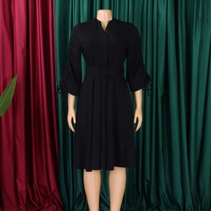 Détail du col en V et de la ceinture sur cette robe plissée noire à manches longues