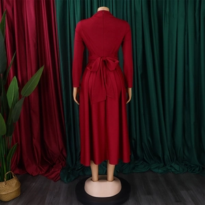 Detail view of the elegant back bow tie on a deep red long-sleeved midi dress