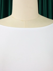 Détail du décolleté blanc élégant sur une robe à manches longues minimaliste