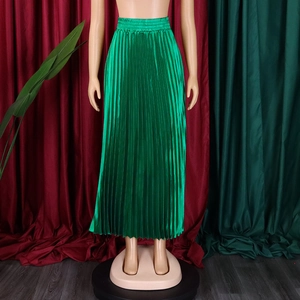 Détail d'une jupe longue plissée vert vif avec fini satiné soyeux et taille élastique