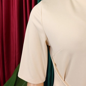 Macro shot of apricot V-neck pencil dress featuring side pleated folds and smooth texture