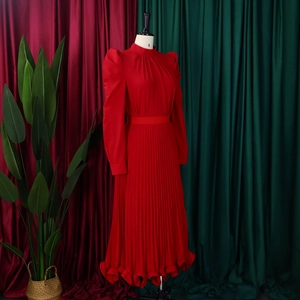 Detail of red bubble sleeve top with pleated skirt set showing fine fabric texture