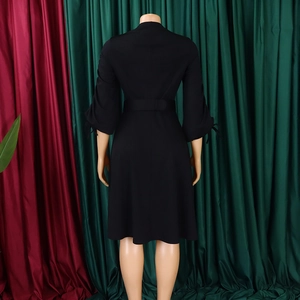 Vue arrière d'une robe noire trapèze avec poignets à nœuds et large ceinture assortie