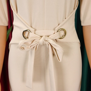 Close-up of elegant pencil dress waist detail with bow tie and gold metal grommets