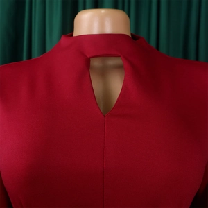 Detail shot of a red pleated dress featuring a keyhole neckline and textured fabric