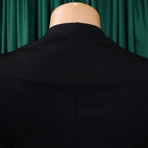 Détail du col arrière et de la couture centrale sur une robe plissée noire de qualité