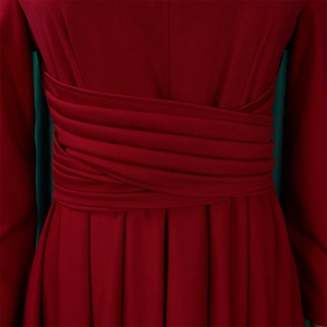 Macro view of the wrap-around pleated waist design on a wine red maxi dress