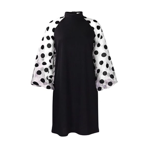 Detail eines schwarzen Kleides mit weißen, transparenten Netzhülsen und Polka-Dots