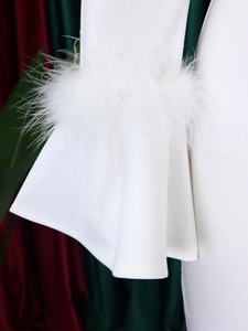 Détail des manches évasées d'une robe blanche avec des bordures en plumes d'autruche