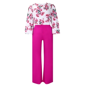 Détail du chemisier à fleurs et du pantalon large taille haute de couleur magenta