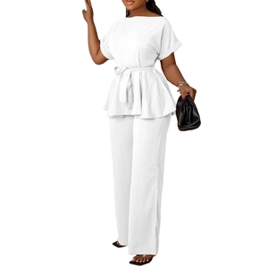 Détail de l'ensemble deux pièces blanc avec haut à basque noué et pantalon large chic
