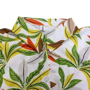 Macro shot of tropical leaf print on fabric with fold-down collar and clear buttons