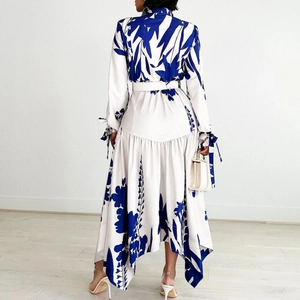 Detail of printed dress with blue leaf pattern and asymmetrical ruffled hemline