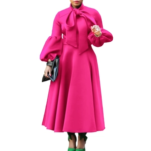 Detail of rose red dress featuring high tie-neck bow and dramatic lantern sleeves