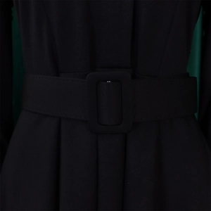 Gros plan d'une robe noire évasée avec une large ceinture à boucle rectangulaire élégante