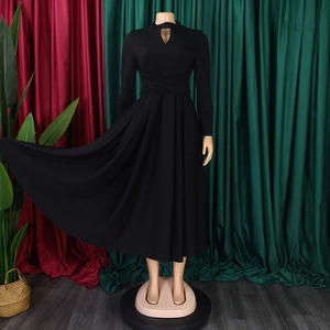 Close-up of the elegant high-neck teardrop cutout and crisscross pleated waist of a black dress
