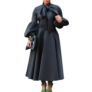 Detail of elegant black midi dress featuring puffy lantern sleeves and a large bow neckline