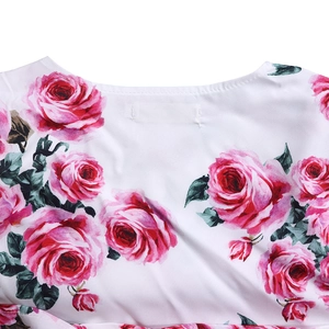 Détail de l'encolure ronde et imprimé floral rose sur une surface en tissu blanc