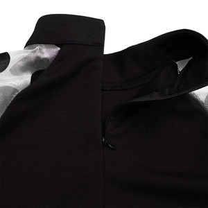 Detail eines unsichtbaren Reißverschlusses an einem Kleid mit gepunkteten Netzärmeln