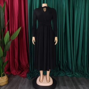 Detail showing elegant black long sleeve dress with waist tie and pleated A-line skirt flow