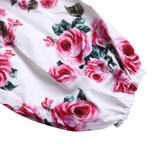 Vue détaillée du poignet élastique avec imprimé floral de roses roses sur tissu blanc