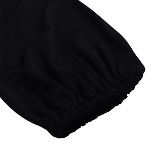 Detail of black knitted dress showing elastic cuffs and fine fabric texture on white background