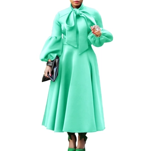 Detail of mint green lantern sleeve dress with elegant bow collar and a flared hemline