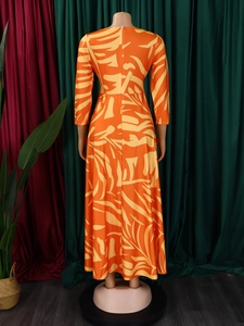 Detail view of tropical leaf print dress back showing the zipper and flowing hemline