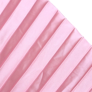 Détail rapproché du tissu plissé rose avec un fini satiné doux sur la jupe longue